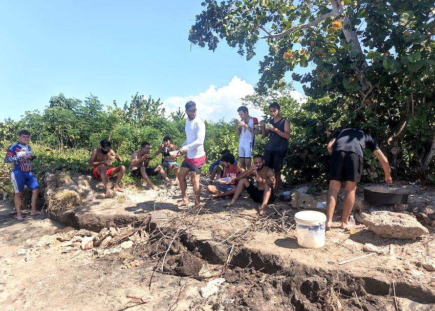 Ciclistas de Búhos Bikepackers compartiendo una caldosa casera durante una excursión a la playa